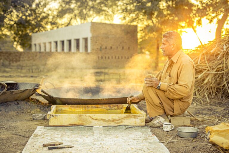 Liquid jaggery syrup being made in a traditional open vessel — warm golden natural sweetener