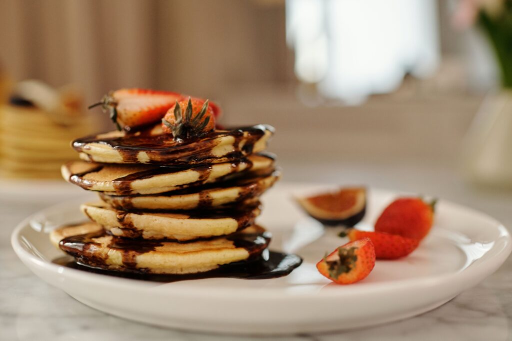 Stack of fluffy date syrup pancakes drizzled with natural date syrup